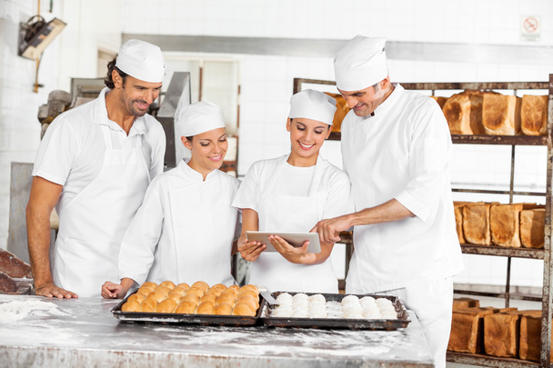 Male And Female Bakers Using Digital Tablet In Bakery - Foto, Imagen