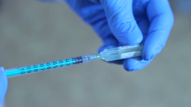 doctor gaining medication from the vial into the syringe - Footage, Video