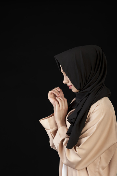 portrait in profile Beautiful Muslim girl in a black scarf on her head on a black background - Фото, зображення