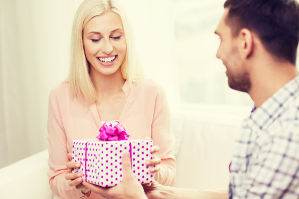 happy man giving woman gift box at home - Foto, Bild