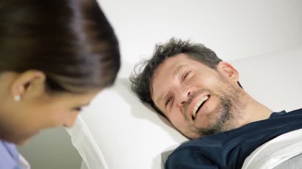 Onnellinen miespotilas sairaalassa hymyilee puhuen lääkärin kanssa lähikuva
 - Materiaali, video