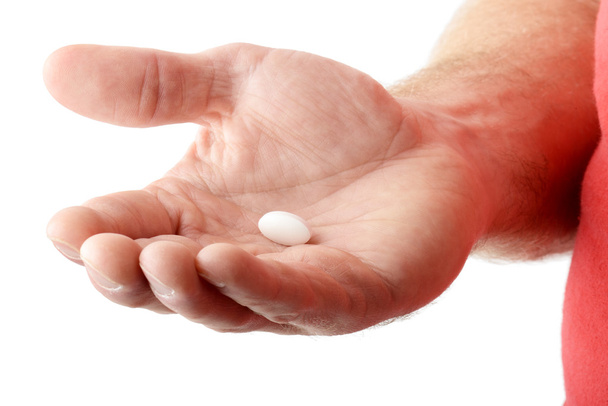 Una mano che tiene una pillola bianca
 - Foto, immagini