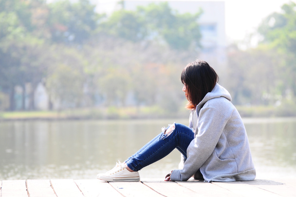 Depresivní žena sedí blízko řeky - Fotografie, Obrázek
