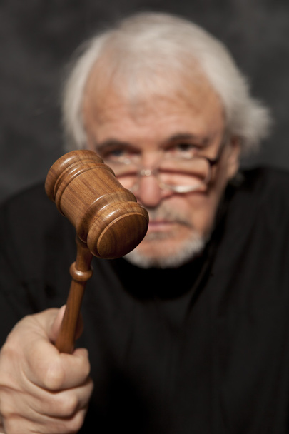 Old male judge in a courtroom striking the gavel - Фото, изображение