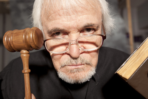Old male judge in a courtroom striking the gavel - Fotó, kép
