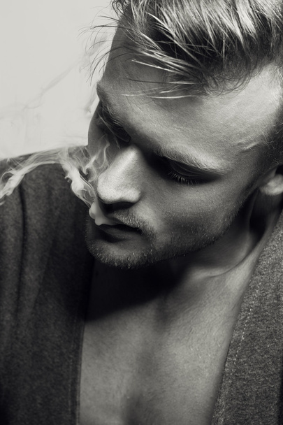  Retrato emotivo del joven modelo de moda fumando cigarrillo. Estilo retro. De cerca. Grabación en blanco y negro
.  - Foto, Imagen