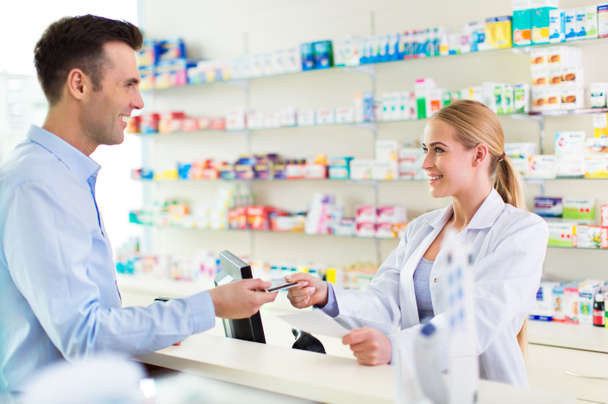Pharmacist and client at pharmacy - Foto, afbeelding
