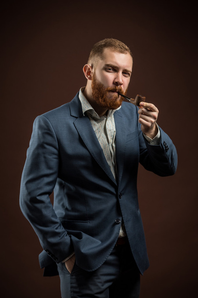 Elegant man with beard holding smoking pipe - Photo, Image