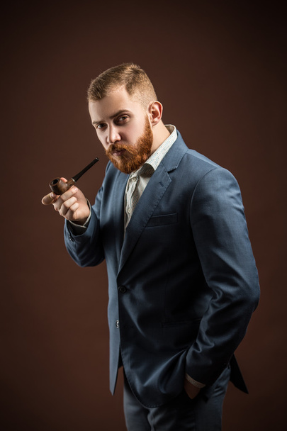 Elegant man with beard holding smoking pipe - Valokuva, kuva