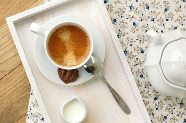 Espresso en taza con leche, galleta y azucarero
 - Foto, imagen