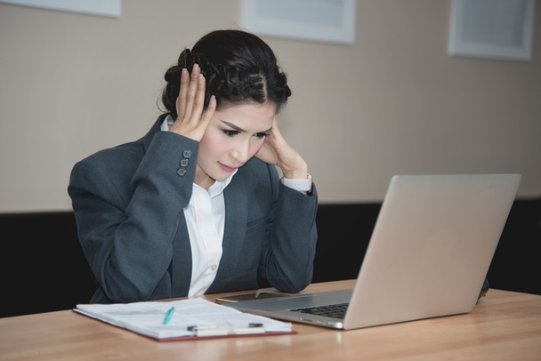 бизнесвумен работает на ноутбуке с головной болью, испытывая стресс в офисе
 - Фото, изображение