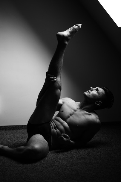 muskulöser Mann mit erhobenem Bein - Foto, Bild