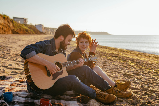 couple playing guitar on beach - Zdjęcie, obraz