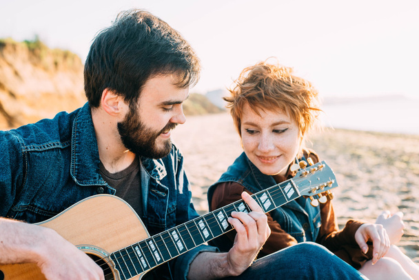 couple playing guitar on beach - Foto, afbeelding