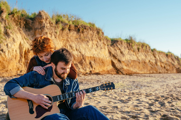 couple playing guitar on beach - Zdjęcie, obraz