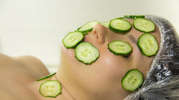Closeup woman on face with cucumber - 写真・画像