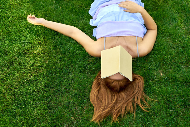 Frau liegt mit Tagebuch auf dem Rasen - Foto, Bild