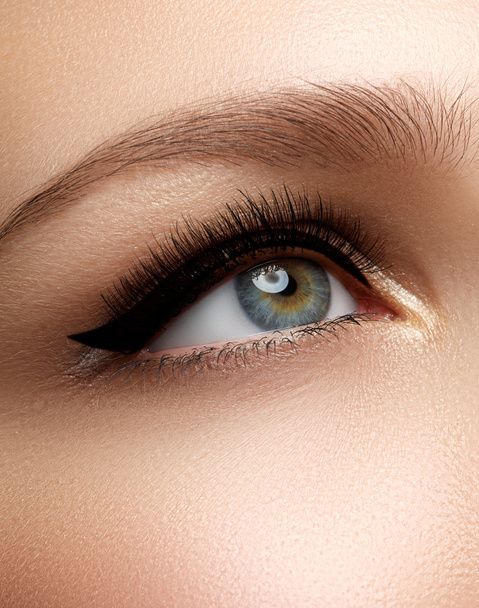 Kosmetiikka & meikki. Kaunis naispuolinen silmä seksikäs musta liner meikki. Muoti iso nuoli muoto naisen silmäluomen. Tyylikäs ilta make-u
 - Valokuva, kuva