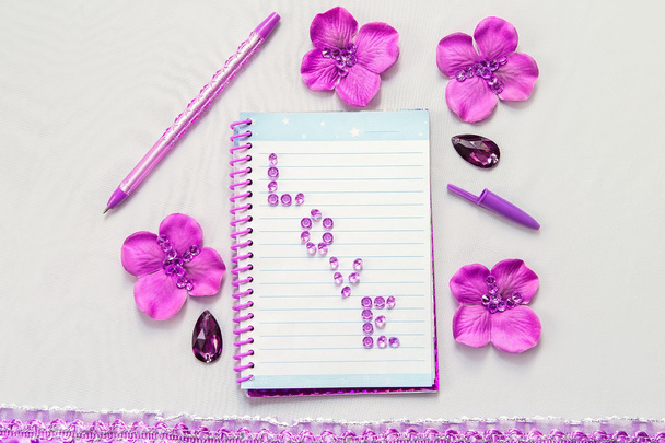 Cuaderno de bolsillo con letras, bolígrafo y flores de lavanda, material para escribir y dibujar en la oficina y la escuela
 - Foto, imagen