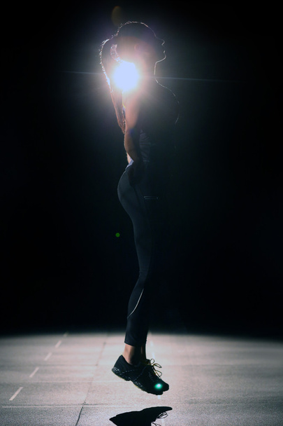 Profile of athletic girl with skipping rope on black background. - Valokuva, kuva