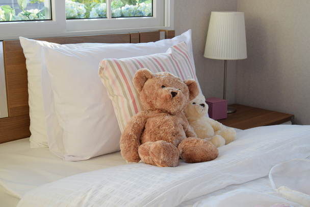 weißes Schlafzimmer dekorativ mit Kissen und Puppen auf dem Bett - Foto, Bild