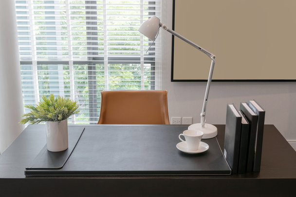 wooden table with lamp and books in modern working room interior - Foto, imagen