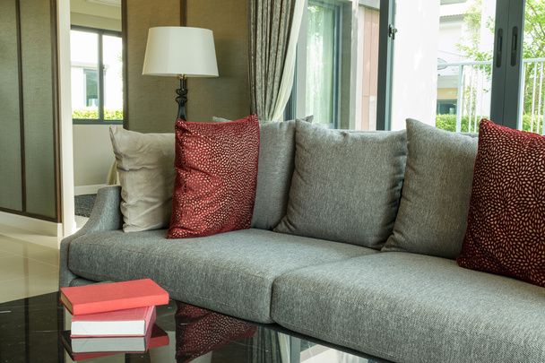 сучасний дизайн вітальні з червоними подушками на дивані та лампі
 - Фото, зображення