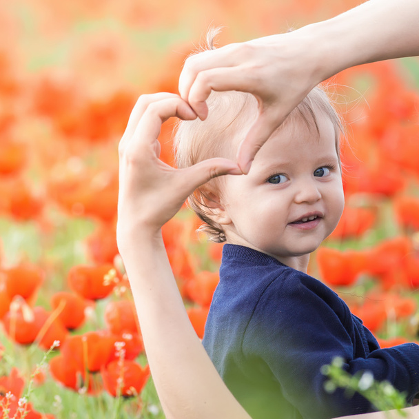 Mother with funny child outdoor at poppy flowers field - Foto, immagini
