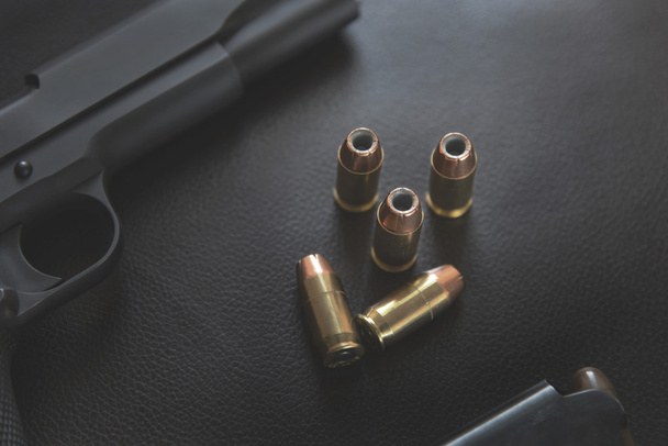 .45-й калибр пули с отверстием около пистолета и магазина на le
 - Фото, изображение