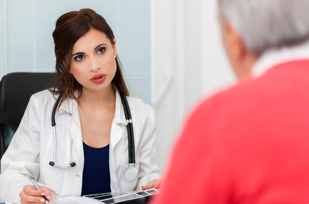 Patient talking to doctor during visit - Φωτογραφία, εικόνα