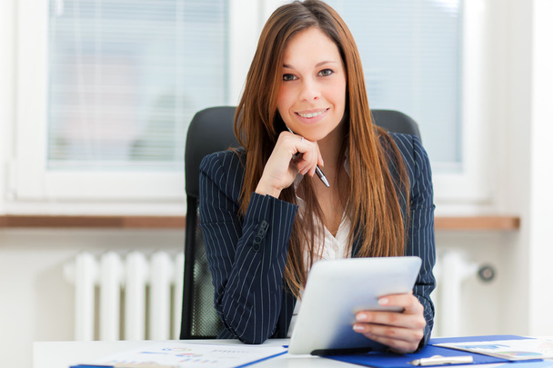 businesswoman holding tablet while sitting at office - Valokuva, kuva