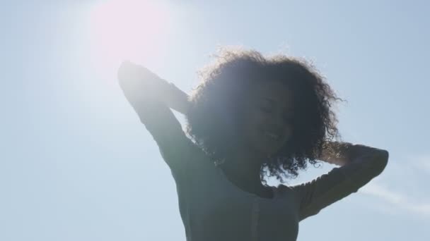 Nuori afro amerikkalainen nainen rentoutuu puistossa auringonlaskun takana
. - Materiaali, video