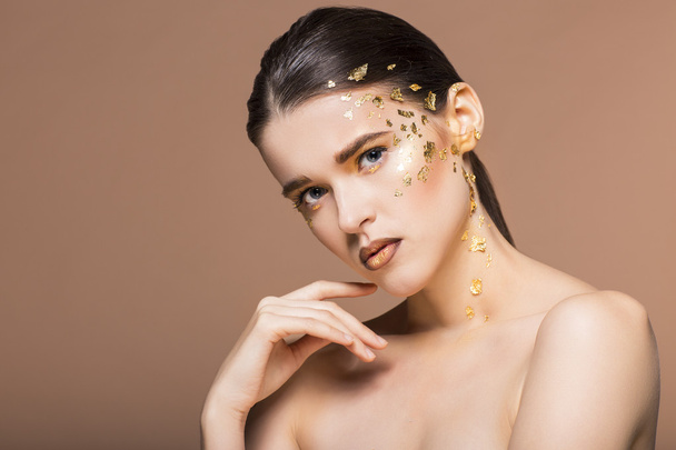 Portrait of a beautiful young woman with bright golden make up - Photo, Image