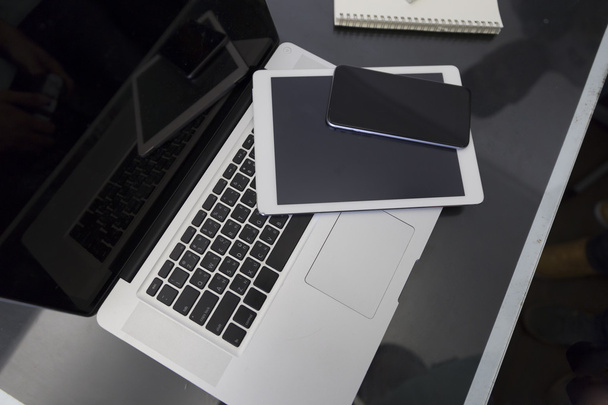 dizüstü bilgisayar, dijital tablet ve siyah masa üstünde hareket eden telefon - Fotoğraf, Görsel