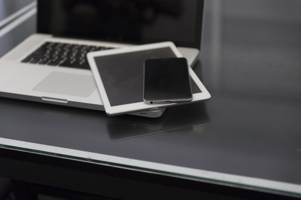 Laptop, digitales Tablet und Handy auf schwarzem Tisch - Foto, Bild