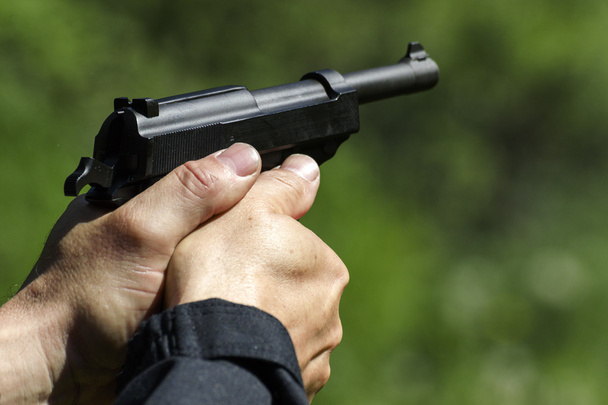 Homem praticando tiro com uma arma
 - Foto, Imagem