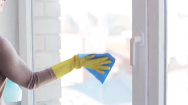 woman in gloves cleaning window with rag - Felvétel, videó