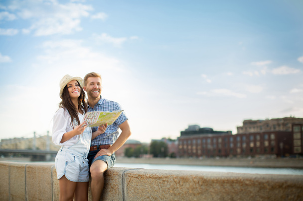 Couple souriant avec une carte
 - Photo, image