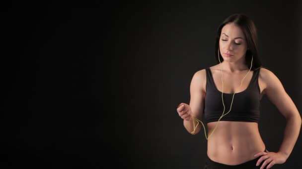 Fit lady chooses music track on her player - Footage, Video