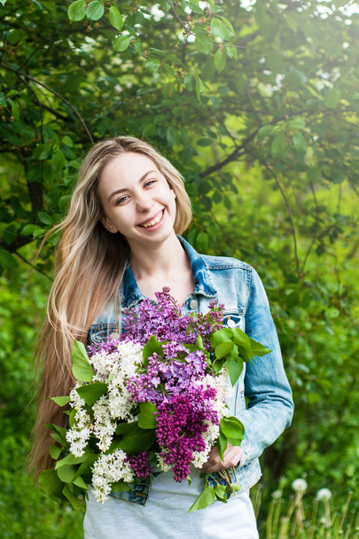 Girl with a bouquet of lilacs - Фото, изображение