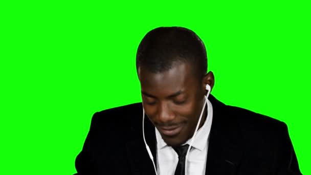 Happy businessman listening to music. Green screen - Materiaali, video