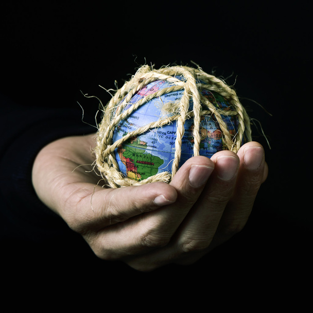 homem com um globo mundial amarrado com corda
 - Foto, Imagem