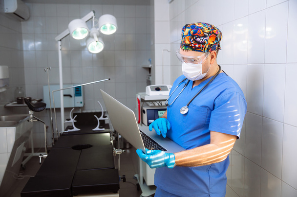 medico con laptop e strumenti medici in sala operatoria dell'ospedale
 - Foto, immagini