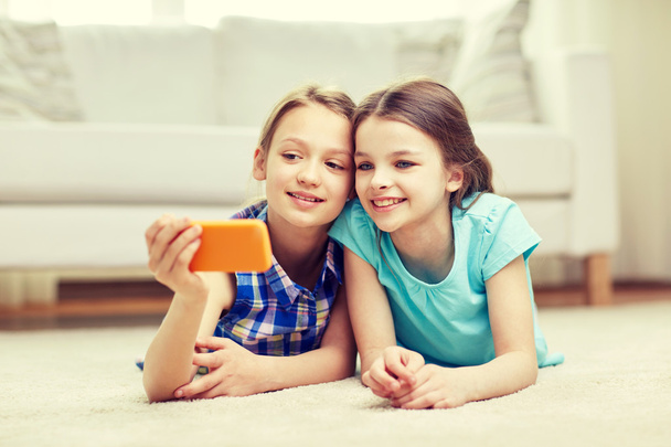 happy girls with smartphone taking selfie at home - Фото, изображение