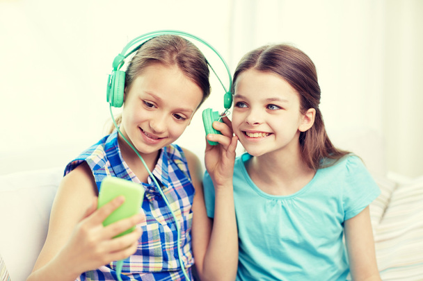 happy girls with smartphone and headphones - Foto, Bild