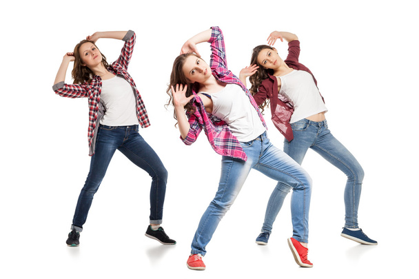 three young women dancing over white background - Foto, afbeelding