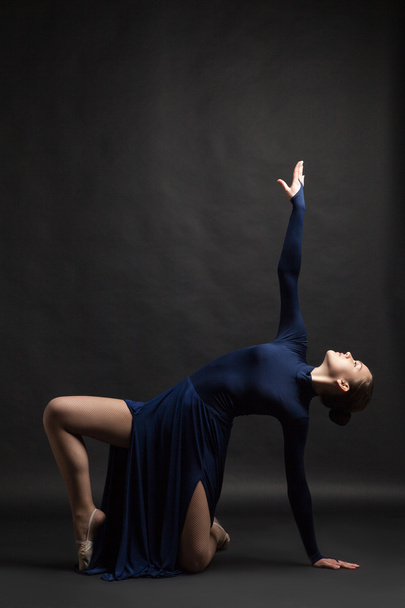 Posing dancer in blue dress over dark background - Foto, Imagem