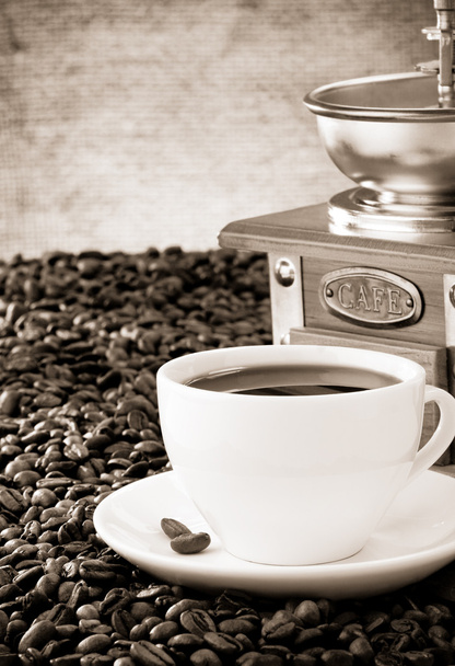 Cup of coffee with beans on sack background - Photo, Image