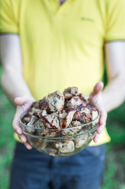 man holding bowl of meat, grilled - Photo, Image