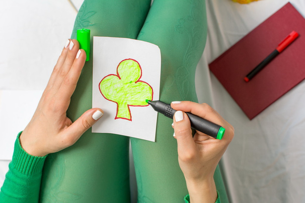 chica en verde dibujar un trébol
 - Foto, imagen